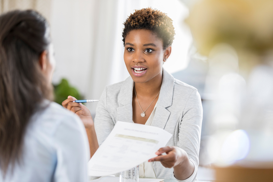 woman discussing paperwork with other woman